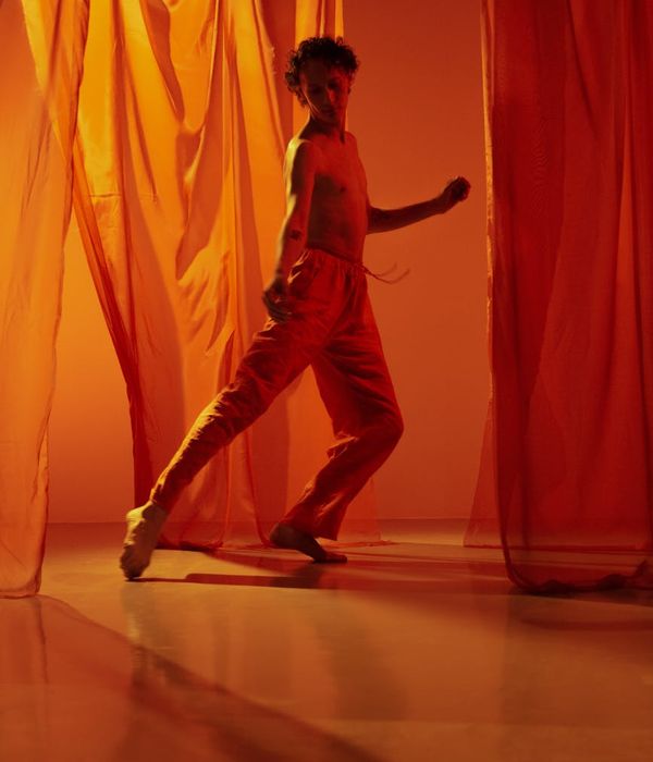 Person performing a smooth, flowing movement in a bright studio.