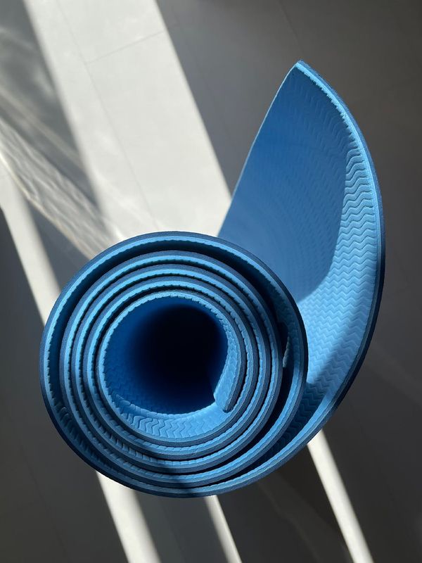 Spacious, bright room with a yoga mat on the floor, ready for a workout.